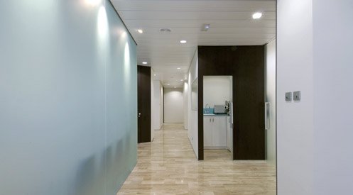 Pasillo de la clínica con mamparas de cristal