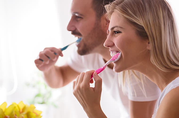 Pareja cepillándose los dientes