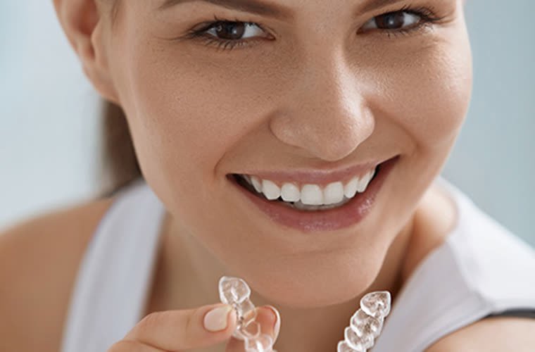 Mujer sonriendo con un alineador transparente